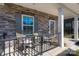 Close up of a front porch with stone accents, seating, and decorative welcome mat at 504 Cranford Dr, Pineville, NC 28134