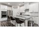 Stylish kitchen featuring white cabinetry, stainless steel appliances, and a spacious island with barstool seating at 504 Cranford Dr, Pineville, NC 28134