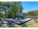 Community playground featuring multiple slides, climbing structures, and benches, surrounded by a lush, green lawn at 504 Cranford Dr, Pineville, NC 28134
