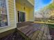 A view of the back deck with sliding glass doors of a yellow home and a wooden fence in the backyard at 5416 River Falls Dr, Charlotte, NC 28215