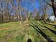 Large backyard with green grass and trees at 5416 River Falls Dr, Charlotte, NC 28215
