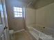 Modest bathroom features a bathtub, toilet, and window for natural light at 5416 River Falls Dr, Charlotte, NC 28215