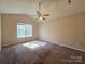 Carpeted bedroom featuring natural light and a ceiling fan at 5416 River Falls Dr, Charlotte, NC 28215
