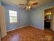 Bedroom with wood floors, a window, and door to bathroom at 5416 River Falls Dr, Charlotte, NC 28215