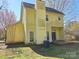 Back exterior of a yellow two-story home featuring a chimney at 5416 River Falls Dr, Charlotte, NC 28215
