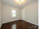 Cozy bedroom with hardwood floors, closet, and a window with views of the outdoors at 5601 Indian Brook Dr, Matthews, NC 28104