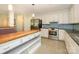 Modern kitchen boasts stainless steel appliances, white cabinetry, island with cooktop and open shelving at 5601 Indian Brook Dr, Matthews, NC 28104