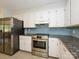 Updated kitchen featuring stainless steel appliances, ample counter space, and white cabinetry at 5601 Indian Brook Dr, Matthews, NC 28104
