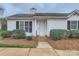 Charming single-story home with a white exterior, complemented by manicured landscaping and a welcoming front door at 5913 Crape Myrtle Ln, Charlotte, NC 28216