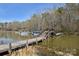 Scenic waterfront view featuring a private boat dock with several boats, offering direct access to the serene lake at 623 Roxboro Dr, Mount Gilead, NC 27306