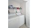 Functional laundry room with washer, dryer, and overhead storage shelves at 623 Roxboro Dr, Mount Gilead, NC 27306