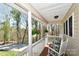 Cozy front porch with rocking chairs, hanging plants, and a view of the surrounding trees at 623 Roxboro Dr, Mount Gilead, NC 27306