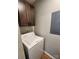 Laundry room featuring a washing machine, upper storage cabinet, and neutral-toned walls at 6423 Town Hall Pl, Harrisburg, NC 28075