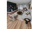 Contemporary living room featuring hardwood floors, stylish furniture, and a unique shelving unit at 6423 Town Hall Pl, Harrisburg, NC 28075