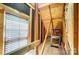 Unfinished attic space with exposed wooden beams, natural light, and ladder at 6519 Summertree Ln, Charlotte, NC 28270