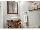 Stylish half-bathroom showcasing a vessel sink on an ornate vanity, with a decorative mirror and artwork at 6519 Summertree Ln, Charlotte, NC 28270