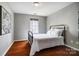 Simple bedroom showcasing hardwood floors, neutral walls, a black iron bed, and a decorative print at 6519 Summertree Ln, Charlotte, NC 28270