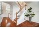 Elegant foyer with hardwood floors, staircase with white spindles, and front door with transom window at 6519 Summertree Ln, Charlotte, NC 28270