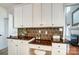 Kitchen desk and cabinets with dark granite countertops and modern backsplash at 6519 Summertree Ln, Charlotte, NC 28270