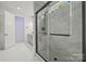 Modern bathroom showcases a glass enclosed shower with rain shower head, gray tile, and matte black hardware at 6548 Emerald Isle Dr, Sherrills Ford, NC 28673