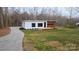 Modern home featuring white siding, wood paneling, and a winding concrete driveway at 6548 Emerald Isle Dr, Sherrills Ford, NC 28673