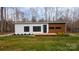 A modern single-story home with minimalist design, wood accents, and well-manicured landscaping at 6548 Emerald Isle Dr, Sherrills Ford, NC 28673