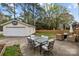 Spacious backyard featuring an outdoor dining area, lounge seating, and a detached garage at 6807 Stoney Ridge Rd, Matthews, NC 28104