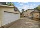 The backyard offers a garage with a basketball hoop and a concrete patio with outdoor furniture at 6807 Stoney Ridge Rd, Matthews, NC 28104
