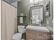 Bathroom featuring a toilet, a sink with drawers and a cabinet, a shower, and a mirror at 6807 Stoney Ridge Rd, Matthews, NC 28104