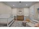 Bedroom with a crib, a dresser with a changing pad, and armchairs at 6807 Stoney Ridge Rd, Matthews, NC 28104