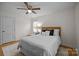 Cozy bedroom with a ceiling fan, one window, a chair and area rug on wood floors at 6807 Stoney Ridge Rd, Matthews, NC 28104