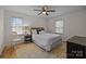 Cozy bedroom with a ceiling fan, two windows, a chair and area rug on wood floors at 6807 Stoney Ridge Rd, Matthews, NC 28104