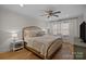 Bedroom with wood floors, white walls and curtains, a ceiling fan, and a bed with decorative pillows at 6807 Stoney Ridge Rd, Matthews, NC 28104