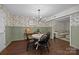 A dining area with wood floors, stylish floral wallpaper, and comfortable seating at 6807 Stoney Ridge Rd, Matthews, NC 28104