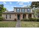 Charming two-story home featuring a brick facade, green shutters, and a welcoming front porch with an American flag at 6807 Stoney Ridge Rd, Matthews, NC 28104