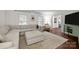 Spacious living room featuring a large sectional sofa, hardwood floors, and abundant natural light from large windows at 6807 Stoney Ridge Rd, Matthews, NC 28104