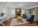 Cozy living room with brick fireplace, wood floors, and large windows providing natural light at 6807 Stoney Ridge Rd, Matthews, NC 28104