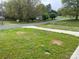 View of a well-kept front yard with mature trees, complemented by a gray sidewalk, and paved driveway at 8124 Wood St, Mount Pleasant, NC 28124