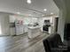 Bright kitchen featuring a center island, white cabinets, stainless steel appliances, and modern gray wood flooring at 8124 Wood St, Mount Pleasant, NC 28124