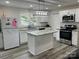 Bright kitchen featuring a center island, white cabinets, and stainless steel appliances at 8124 Wood St, Mount Pleasant, NC 28124