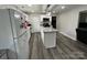 Bright kitchen featuring a center island, white cabinets, stainless steel appliances, and modern gray wood flooring at 8124 Wood St, Mount Pleasant, NC 28124