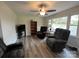 Bright living room with ceiling fan, grey flooring, and large windows at 8124 Wood St, Mount Pleasant, NC 28124