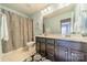 Well-lit bathroom with dual sinks, dark cabinetry, and a large mirror, offering a functional and stylish space at 9001 Lanark Ln, Indian Land, SC 29707