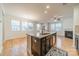 Kitchen island with granite countertop and sink, connecting to the living and dining areas at 9001 Lanark Ln, Indian Land, SC 29707