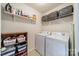 Well-organized laundry room featuring a washer, dryer, shelving for storage, and ample space for laundry tasks at 9001 Lanark Ln, Indian Land, SC 29707