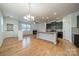 Open-concept living room and kitchen with hardwood floors, fireplace, and modern lighting at 9001 Lanark Ln, Indian Land, SC 29707