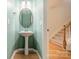 Charming powder room with pedestal sink and decorative mirror, located near staircase, for added convenience at 9001 Lanark Ln, Indian Land, SC 29707