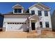 Charming two-story home with white siding, stone accents, a garage, and a well-manicured yard, perfect for curb appeal at 919 Mankey Dr, Huntersville, NC 28078