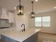 Modern kitchen showcasing a large island with sink and pendant lights, sleek countertops, and stainless steel appliances at 919 Mankey Dr, Huntersville, NC 28078