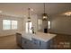 Open-concept kitchen featuring a spacious island with a farmhouse sink, stainless steel appliances, and modern pendant lighting at 919 Mankey Dr, Huntersville, NC 28078